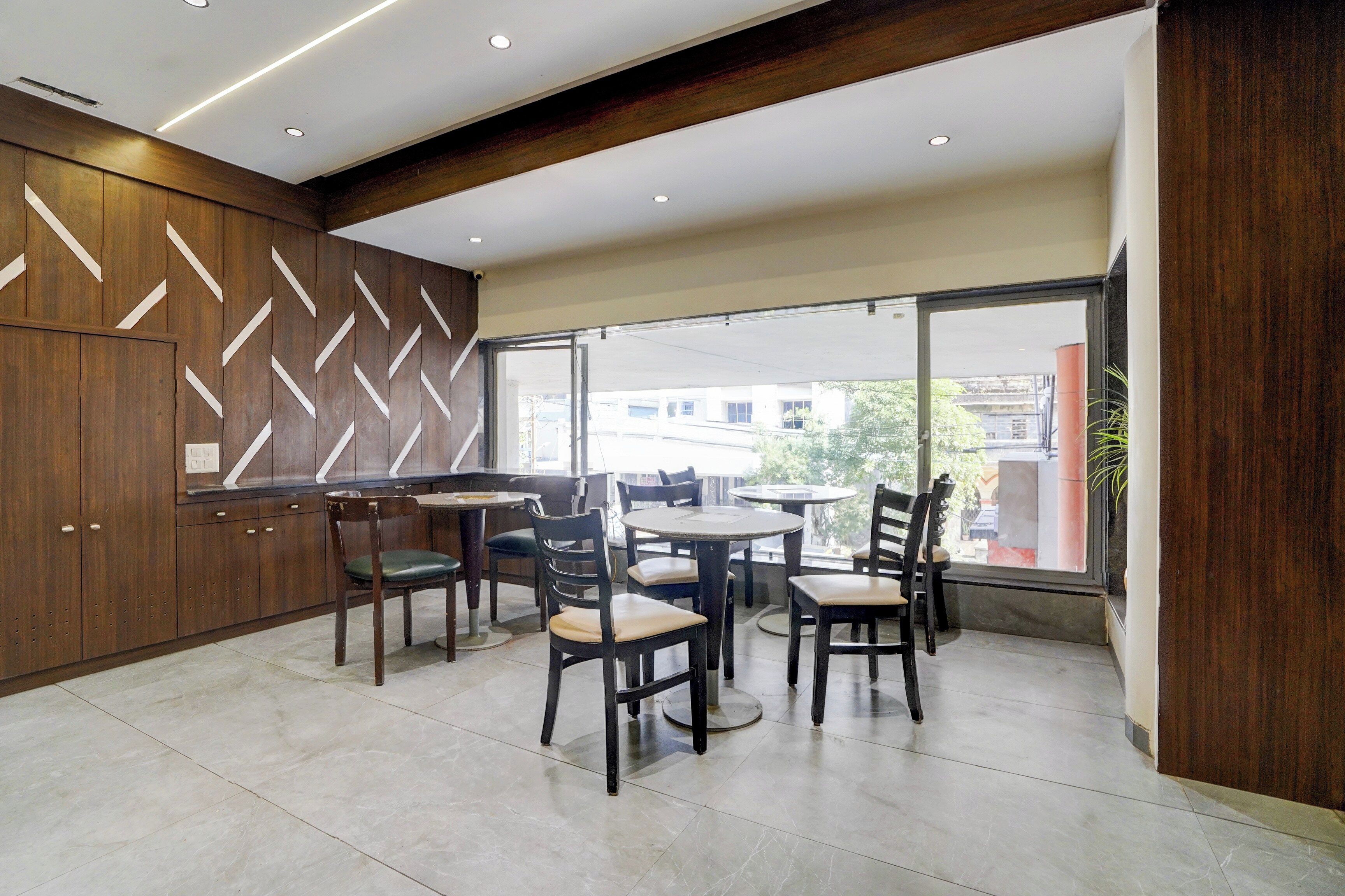 Un intérieur moderne avec un coin repas agrémenté de meubles en bois et offrant une vue dégagée grâce à de grandes fenêtres.