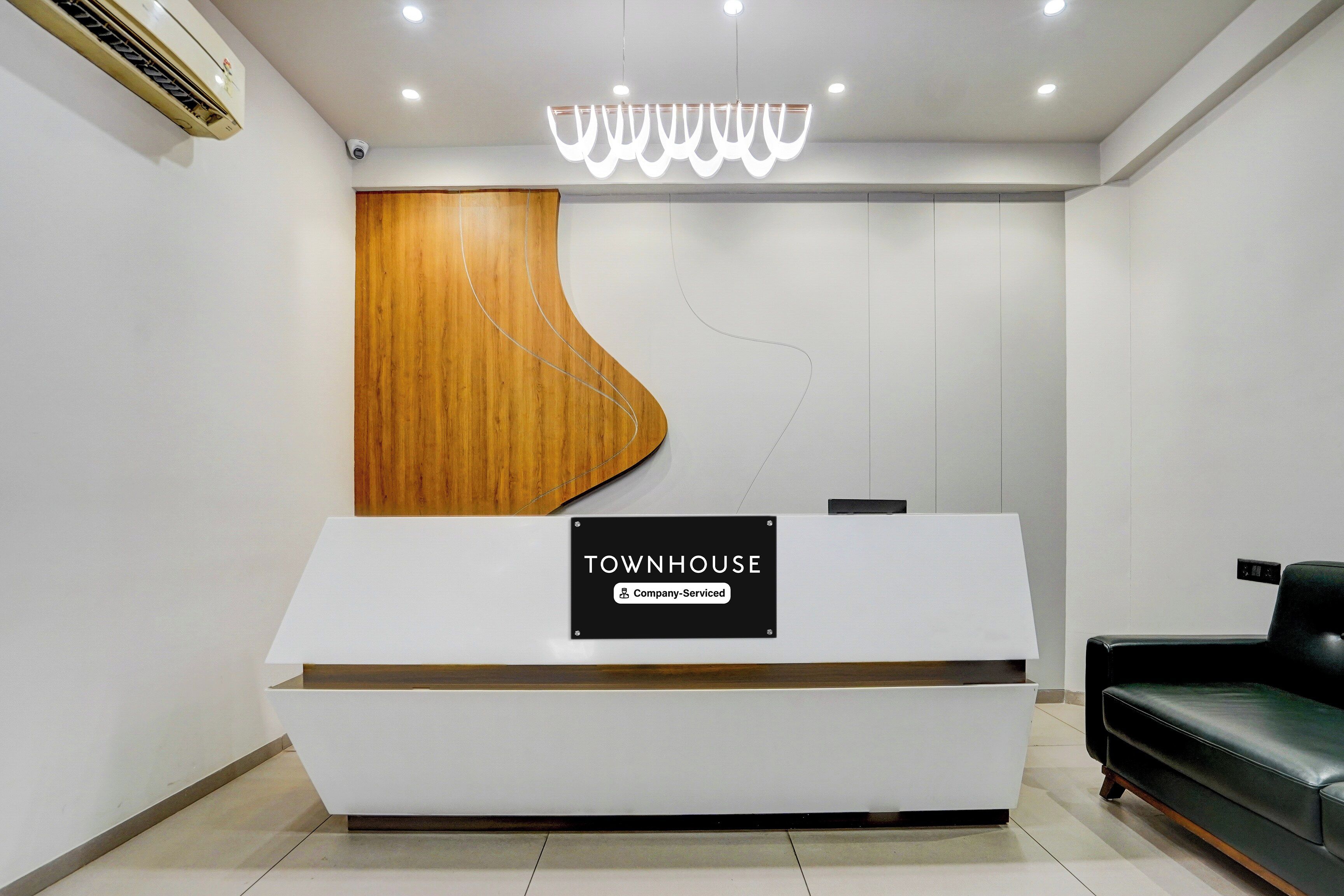Un comptoir d’accueil avec une pancarte indiquant : « Services de la société TOWNHOUSE ».