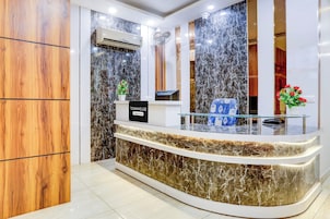 A reception desk with a marble countertop, a sign indicating 'Townhouse Company-Serviced', and a security camera above.