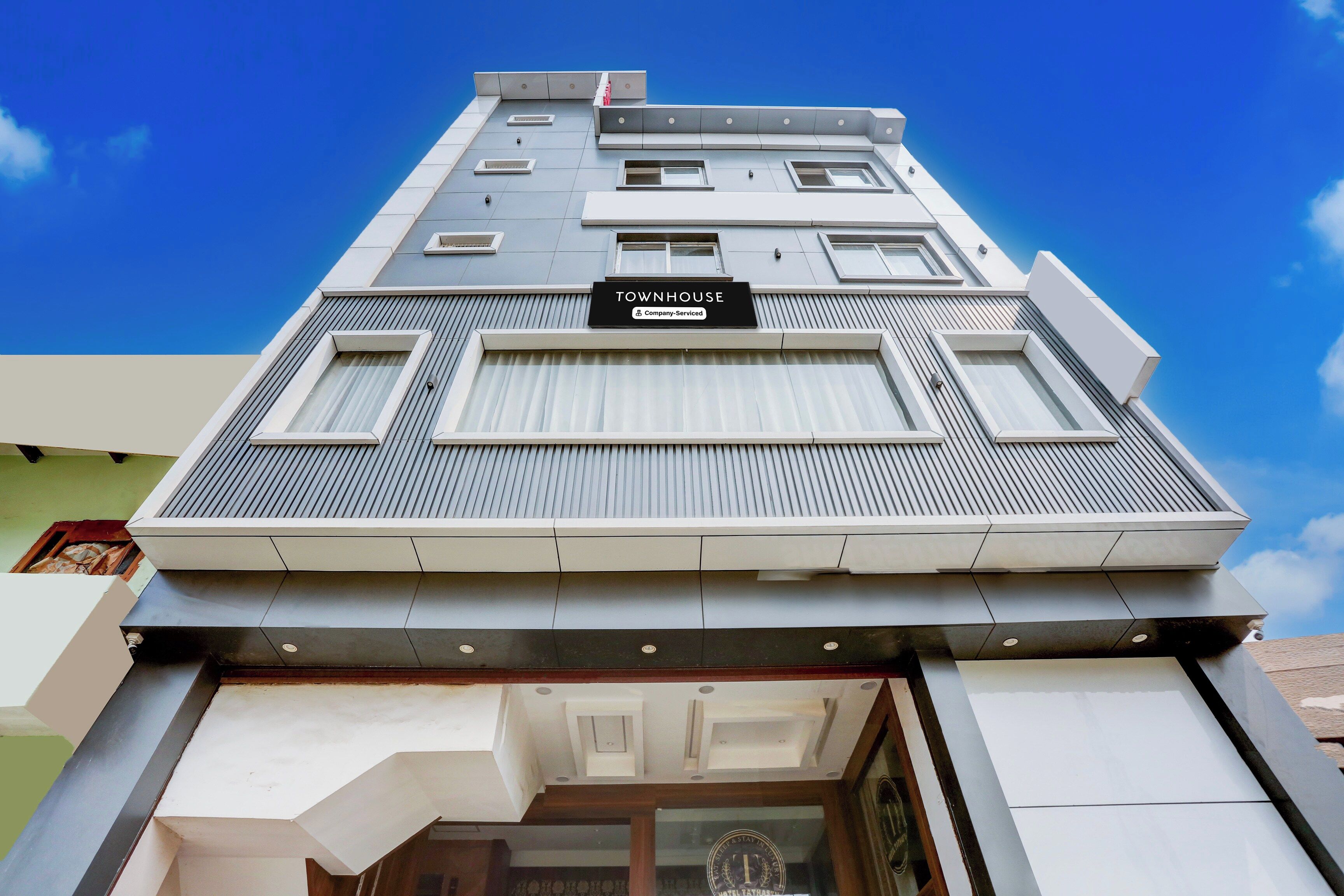 Un edificio moderno con un letrero que dice 'TOWNHOUSE Company Serviced'.