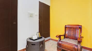 A room with a wooden chair, a small stool, and a wall socket.