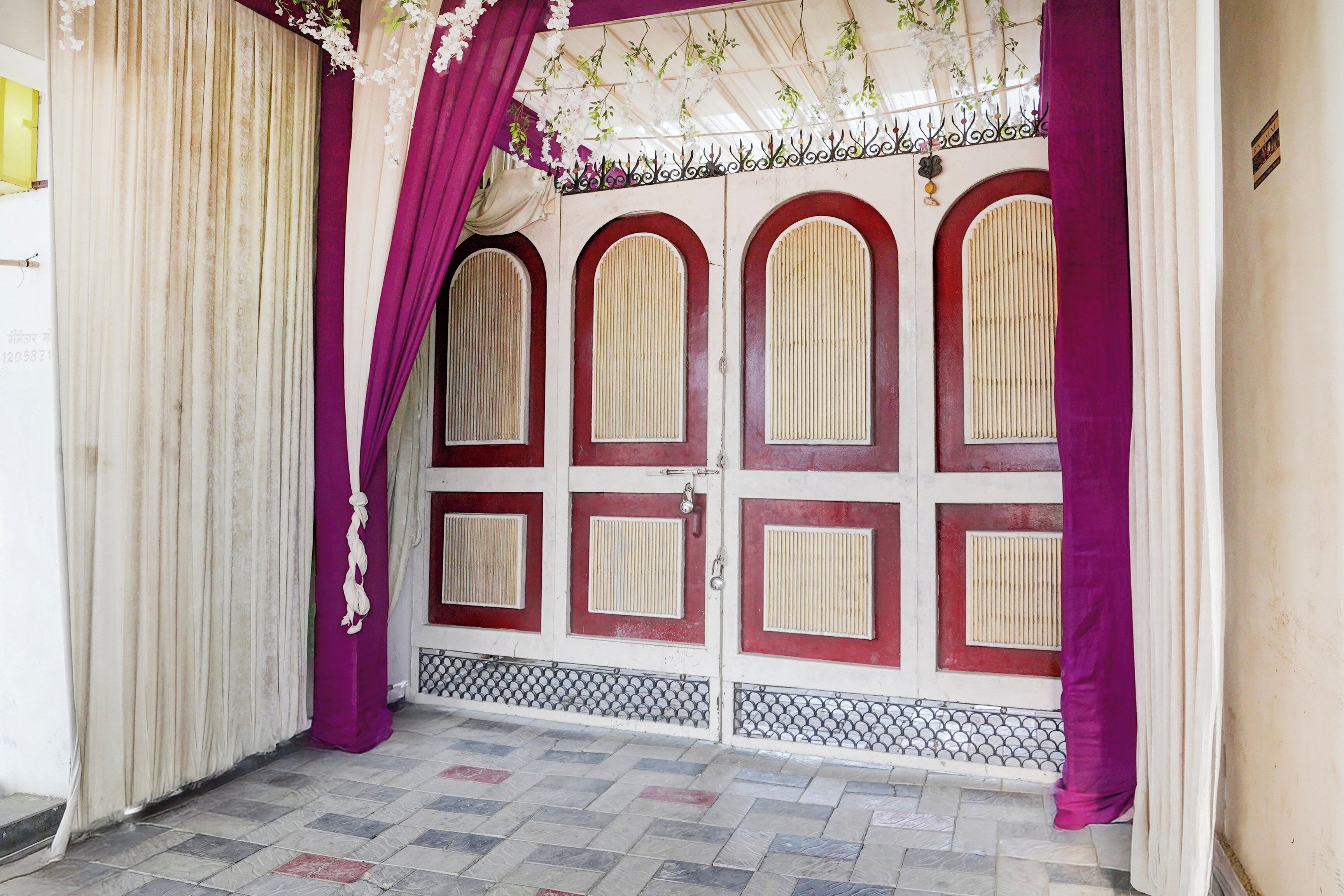 A closed door with a decorative arch and a patterned floor.