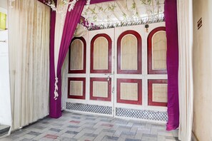 A closed door with a decorative arch and a patterned floor.