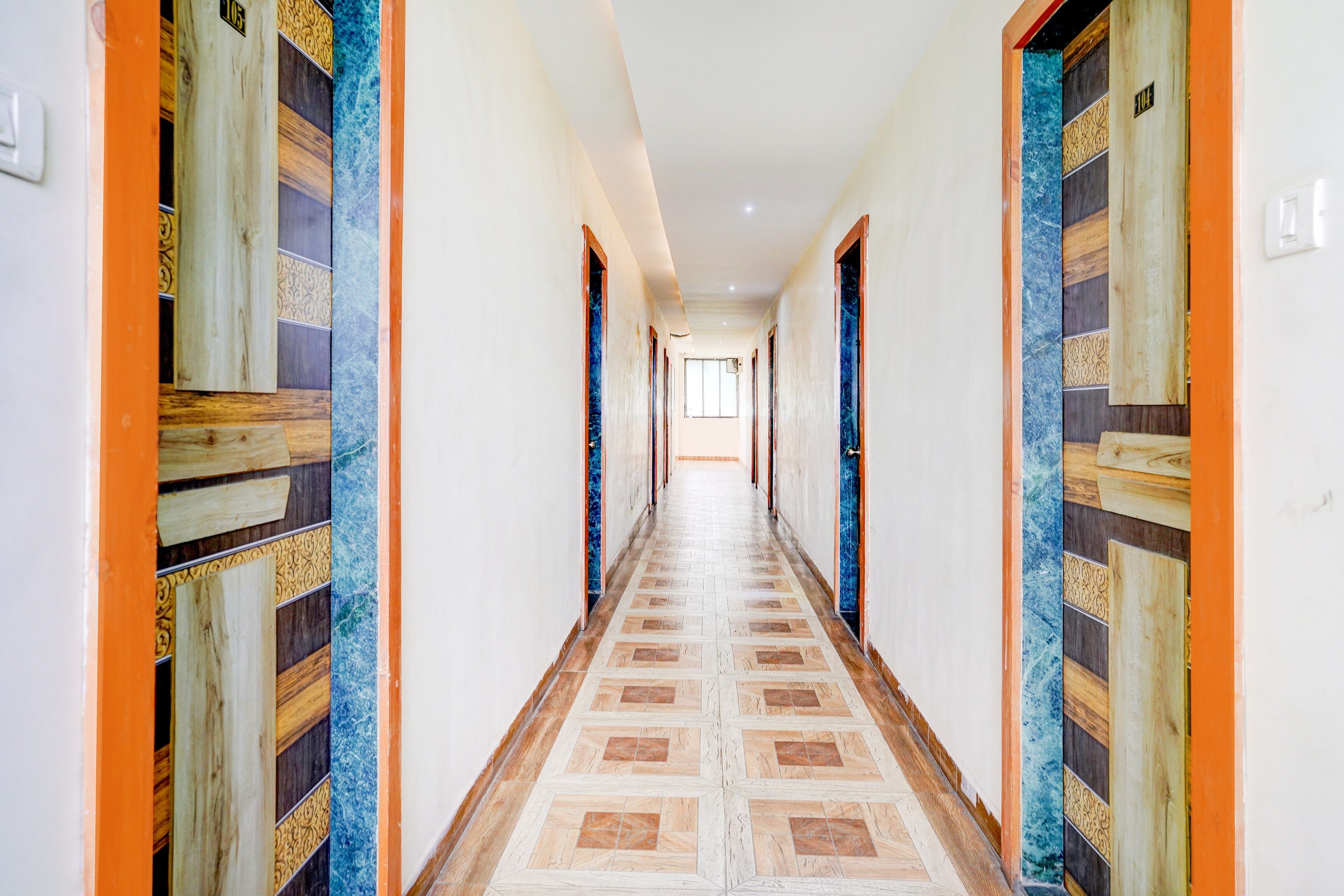 A long hallway with patterned doors and a tiled floor.