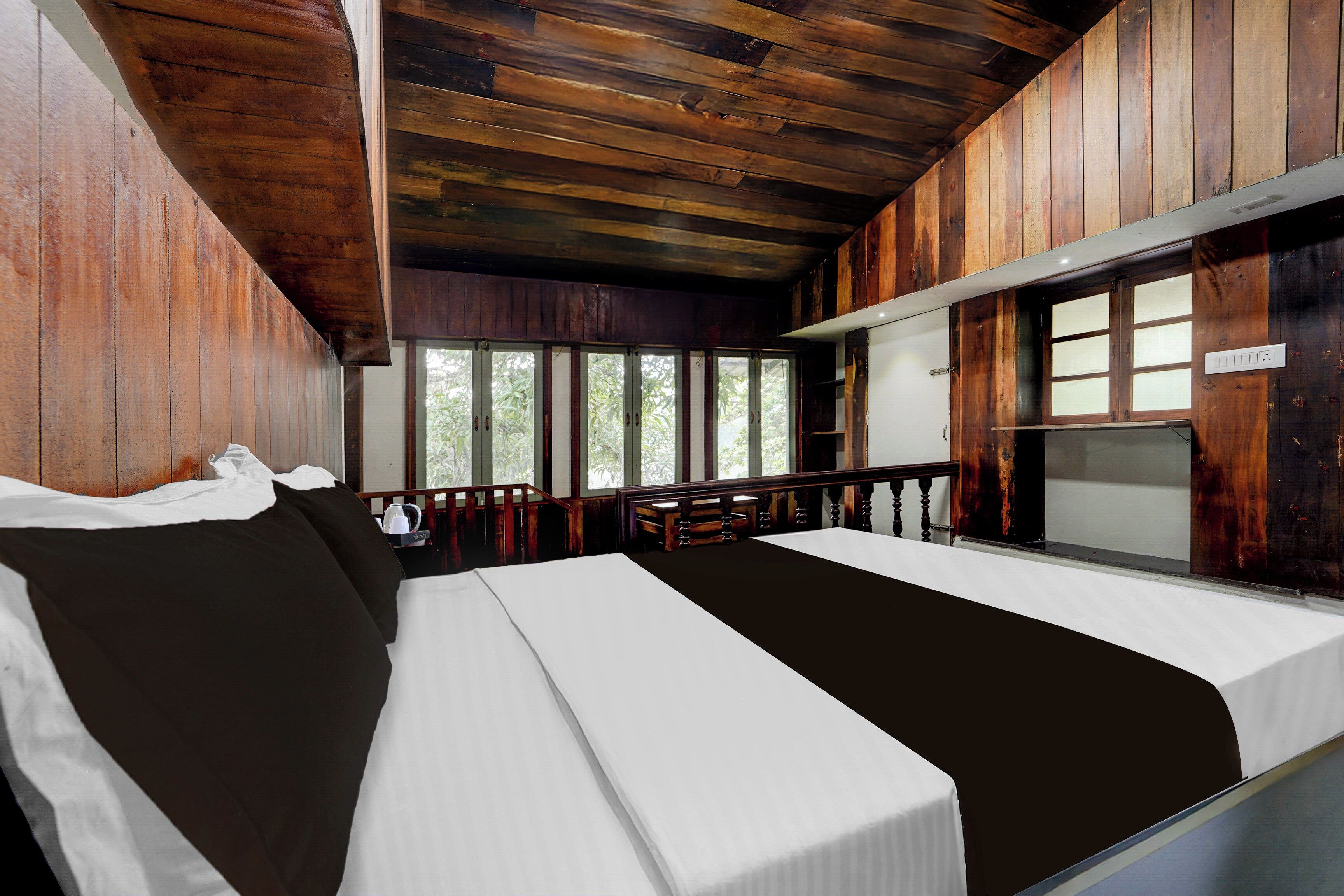 Quarto com cama, janela e vista para árvores.