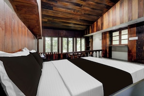 Una habitación con cama, ventana y vistas a árboles.