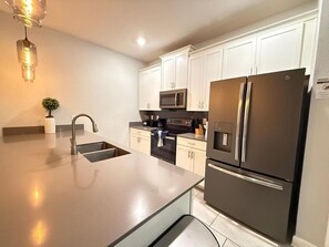 A modern kitchen with a stainless steel refrigerator, a microwave, and a sink. - LUXURY 5BR PRIVATE POOL 8 MIN TO DISNEY SLEEPS 13 (Kissimmee)