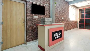 Mostrador de recepción de hotel con un cartel que indica servicio corporativo.