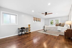 A bedroom with a bed, a desk, a chair, a ceiling fan, and a window with curtains. - Hillside Family Retreat · 3BR + Library · Near the Oakland Zoo (Oakland)