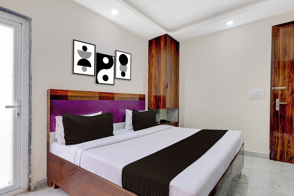 Un dormitorio con una cama, un armario de madera y dos cuadros en la pared.