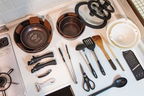 A kitchen with various utensils and cookware, including a frying pan, spatula, and colander. - Beautiful parkview 3-bedroom condo with AC/WiFi in Hokkaido's capital Sapporo (Sapporo)