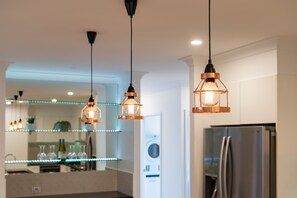 A kitchen with pendant lights, a refrigerator, and a washing machine. - Whitsunday Sanctuary Retreat - Mountain Views (Jubilee Pocket)
