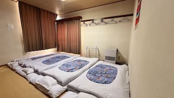 A hotel room with a bed, a heater, and a wall-mounted drying rack.