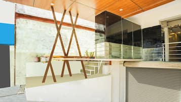 Un interior moderno con techo de madera, barandilla de cristal y puerta de garaje cerrada.