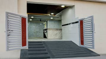 Una entrada de edificio con una rampa que lleva a una puerta, un letrero que dice 'TOWNHOUSE' y un muro de mármol al fondo.