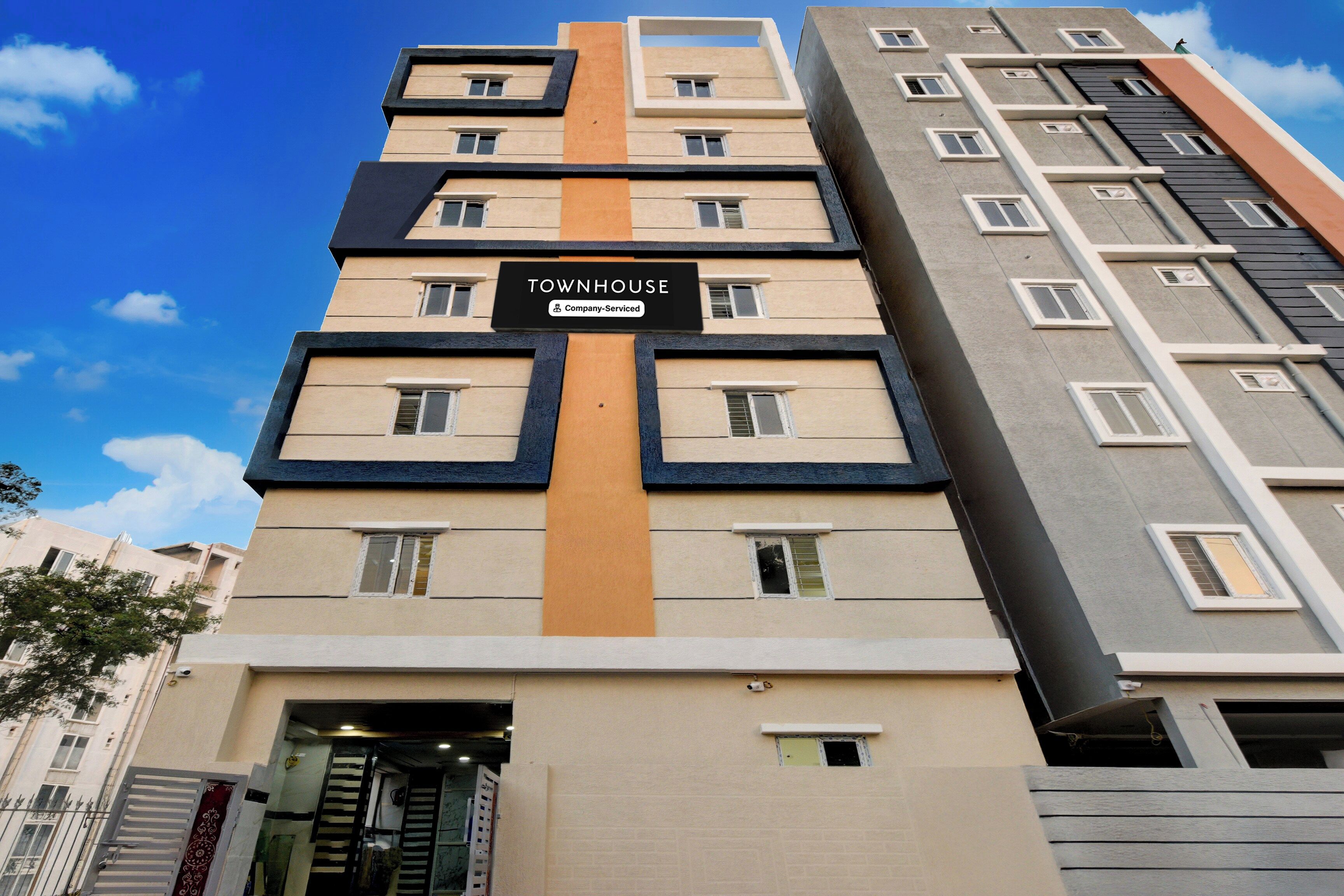 A multi-story building with a sign indicating it is a company-serviced townhouse.