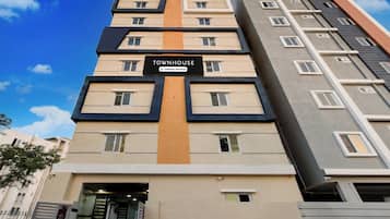 Um edifício de vários andares com uma placa indicando que é uma casa geminada com serviços para empresas.