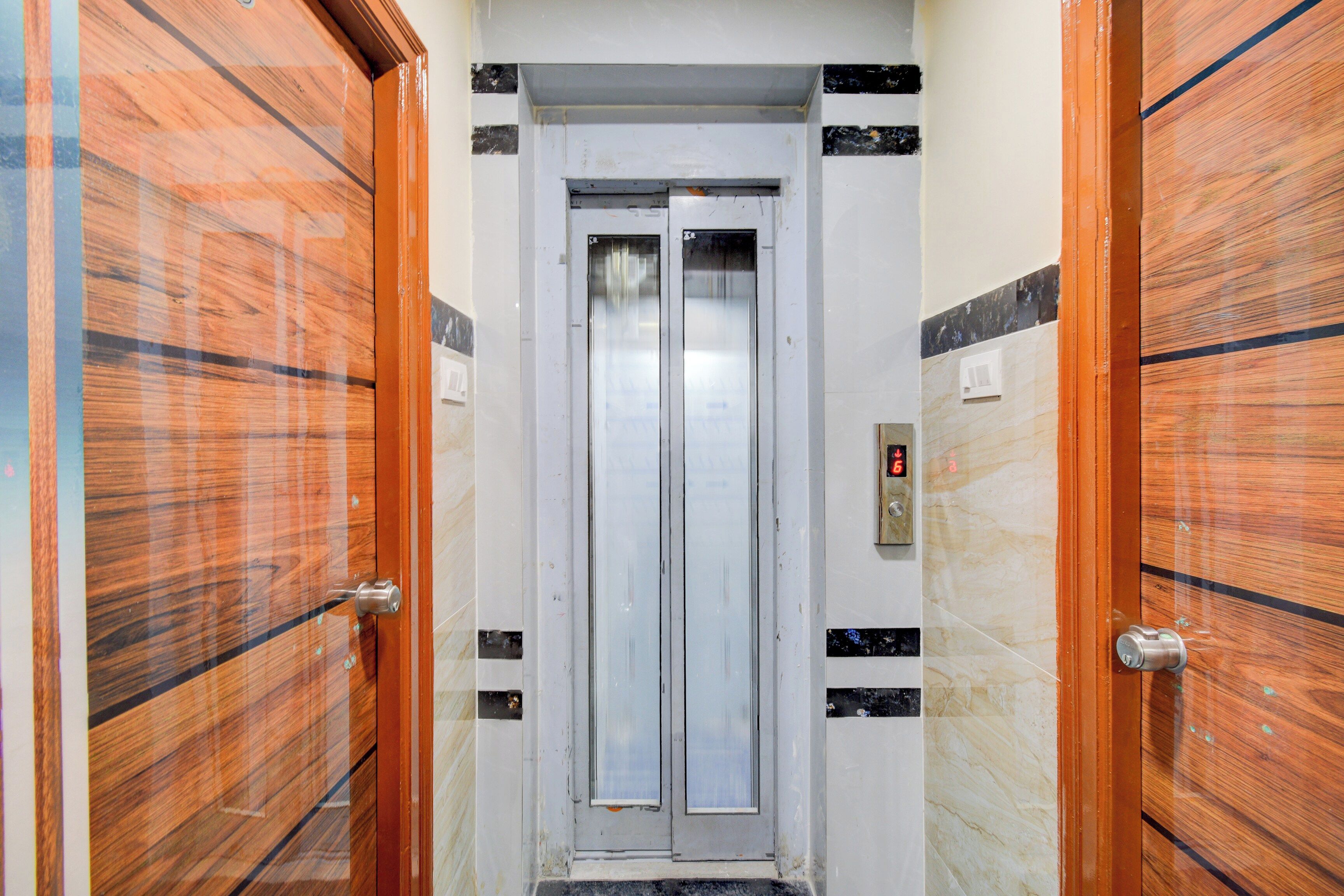 A hallway with a door leading to an elevator.