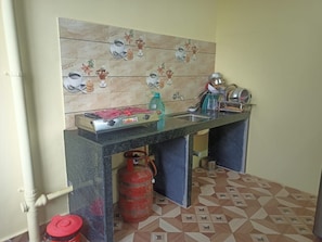 A kitchen with a gas stove, sink, and a tiled backsplash.
