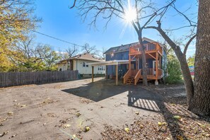 A two-story house with a covered patio and a wooden deck. - Jayhawk House - 5 min to KU/DWTN (Lawrence)