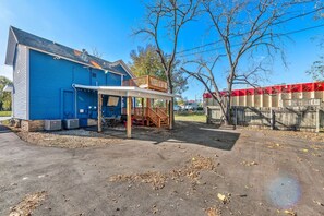 A residential property with a blue house, a covered patio, and a fenced yard. - Jayhawk House - 5 min to KU/DWTN (Lawrence)