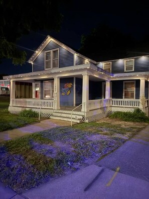 A two-story house with a porch and a small garden area. - Jayhawk House - 5 min to KU/DWTN (Lawrence)