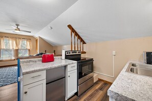 A kitchen with a built-in oven, a microwave, and a stainless steel sink. - Jayhawk House - 5 min to KU/DWTN (Lawrence)