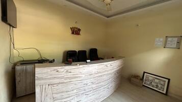 A reception desk with a curved design, a ceiling fan, and a framed picture on the wall.