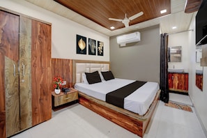 Ein Schlafzimmer mit einem Bett, einem Holzschrank, einem Nachttisch und einem Deckenventilator.