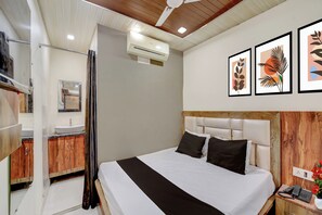 Habitación de hotel con cama, baño y ventilador de techo.