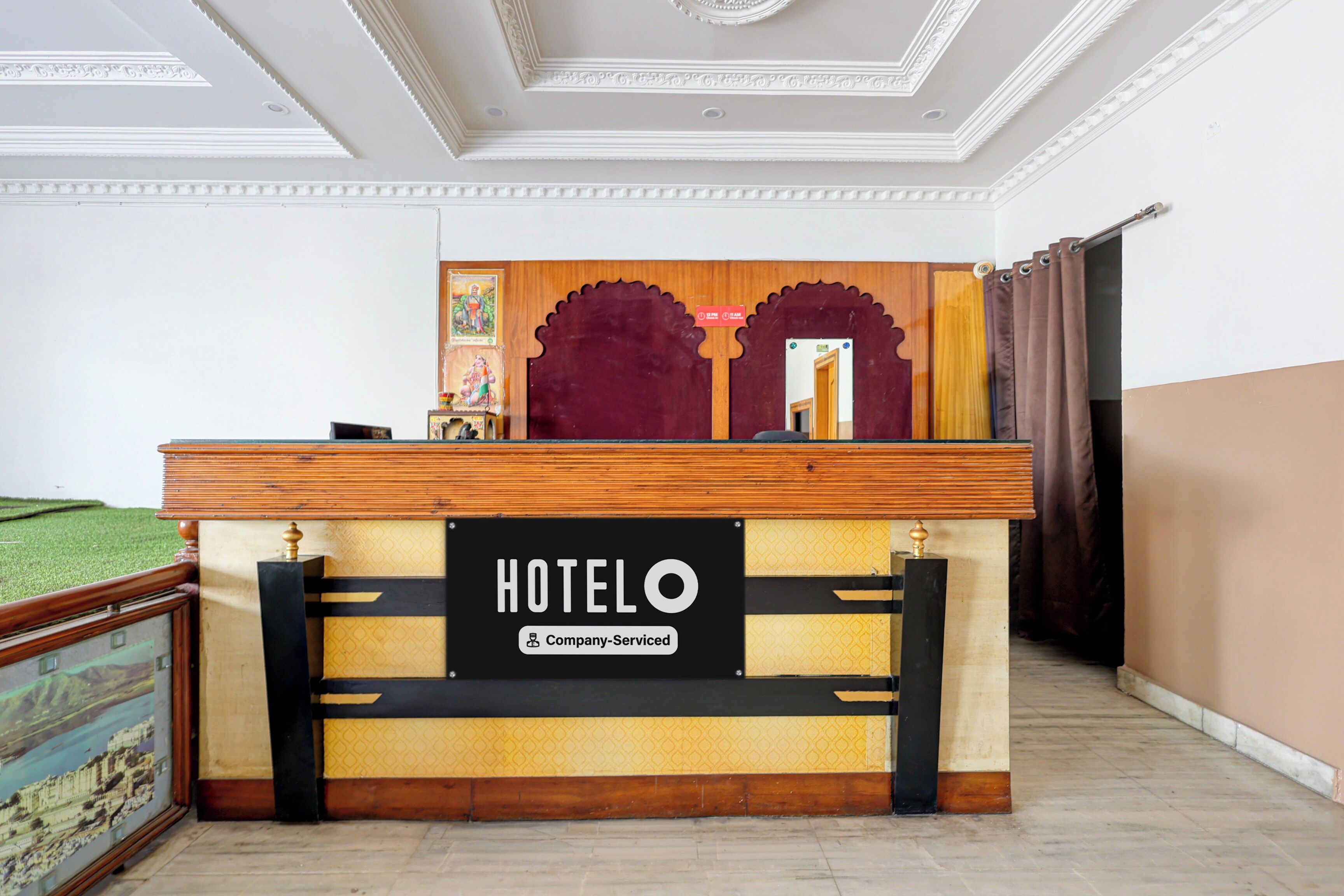 Un mostrador de recepción de hotel con un cartel que dice 'HOTEL', una etiqueta de servicio de empresa y una barra de madera.