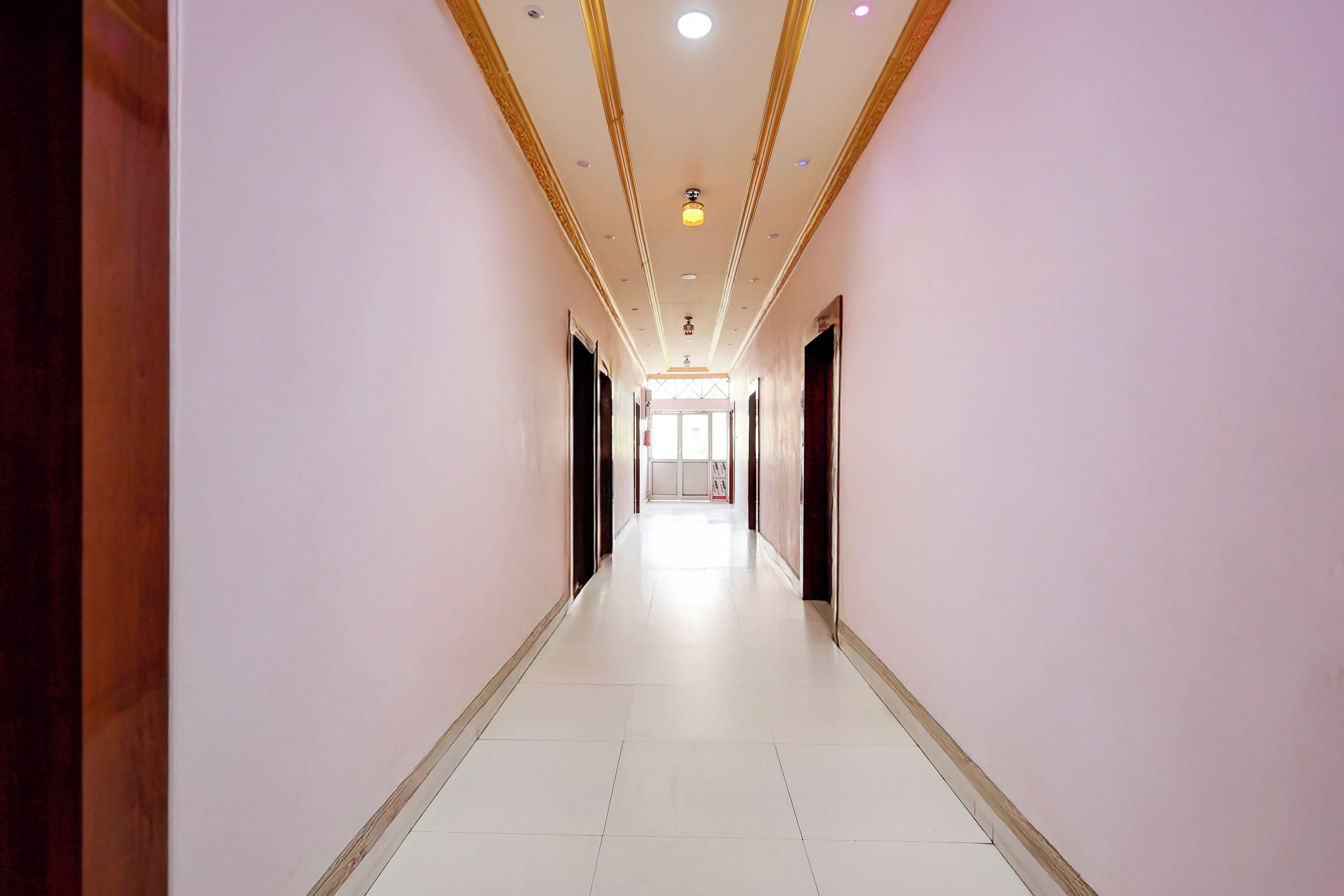A long, narrow hallway with a tiled floor and a ceiling with recessed lighting.