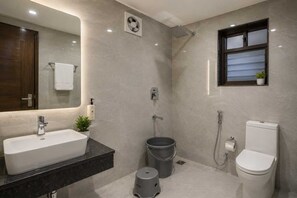 Un baño moderno con un lavamanos grande, inodoro, ducha y una ventana pequeña.