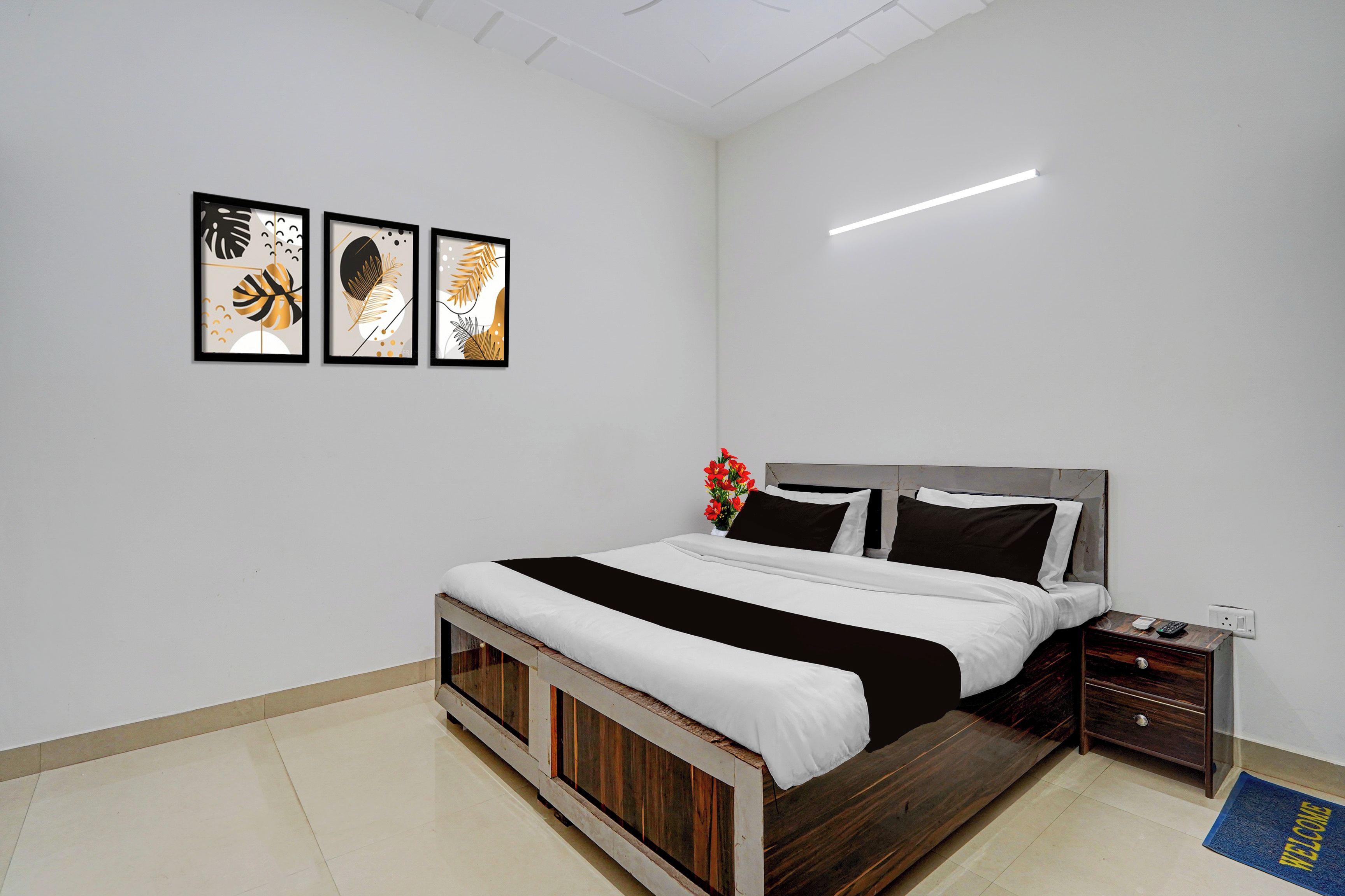 Une chambre à coucher avec un lit, des tables de chevet et un luminaire fixé au mur.