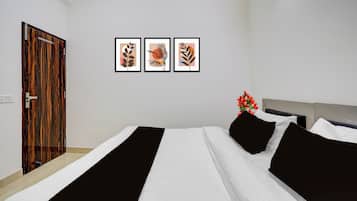 Une chambre d’hôtel avec un lit, une porte et trois œuvres d’art encadrées accrochées au mur.