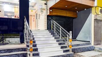 A staircase with metal railings and marble steps leading to a closed door.