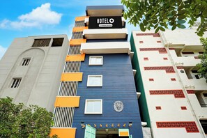 A hotel building with a sign indicating it is company-serviced. - Super Hotel O Acharya Institute Of (Bengaluru)