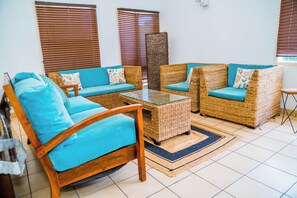 A room with a sofa, two armchairs, a coffee table, and a decorative wall piece. - Charming 3-bedroom apartment with AC in peaceful Candolim (Arpora)