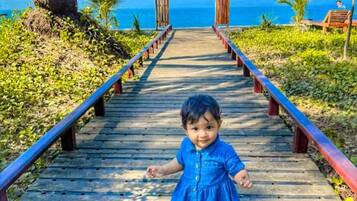A wooden pathway leading to a wooden structure with a view of the ocean.