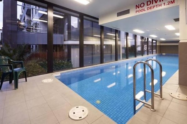 An indoor swimming pool with a sign indicating no diving and a depth of 1.2 meters. - Spacious Seaviews (Melbourne)