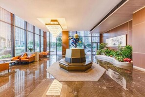 A modern lobby with a central seating area, large windows, and a chandelier. - Kechuang Hotel (Shenzhen)