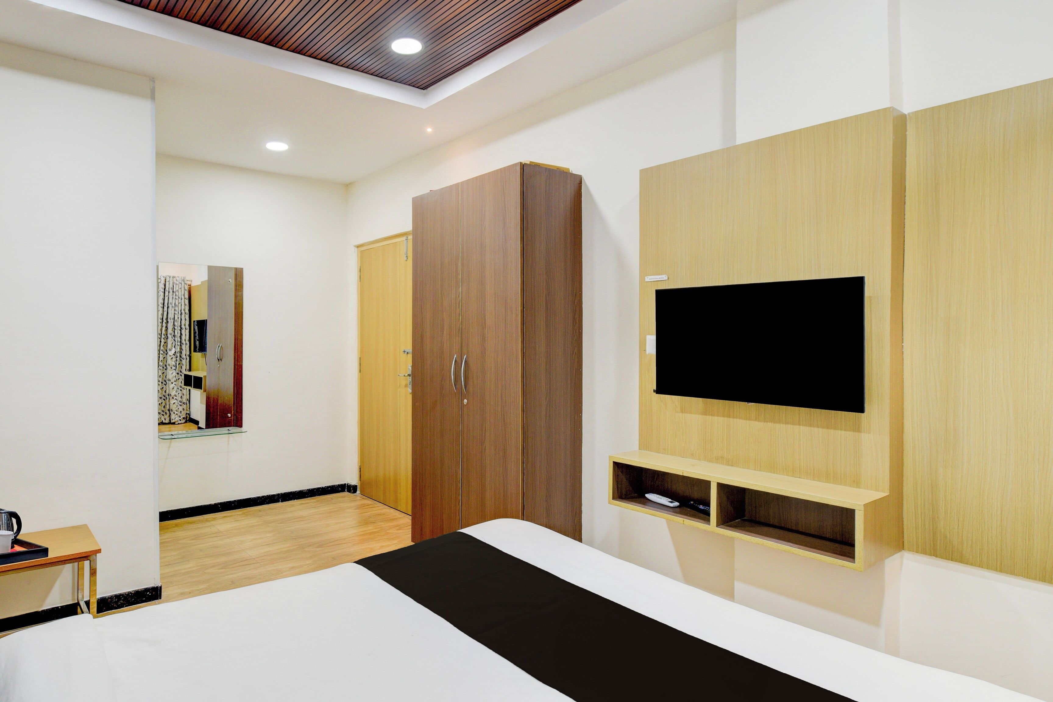 Un dormitorio moderno con cama, armario y televisor montado.