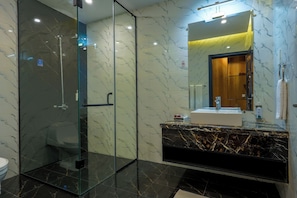 A modern bathroom with a glass-enclosed shower, a marble vanity, and a large mirror. - Hotel One Top City Islamabd  (Islamabad)