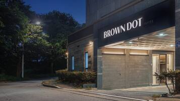 Das Brown Dot Hotel mit moderner Fassade und beleuchtetem Eingang.
