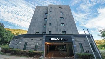 A modern hotel entrance with a sign reading 'BROWN DOT HOTEL.'