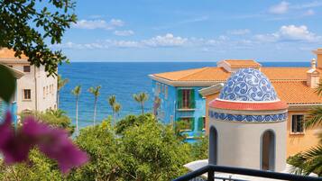 A coastal building with a blue facade and a decorative dome, overlooking the sea.