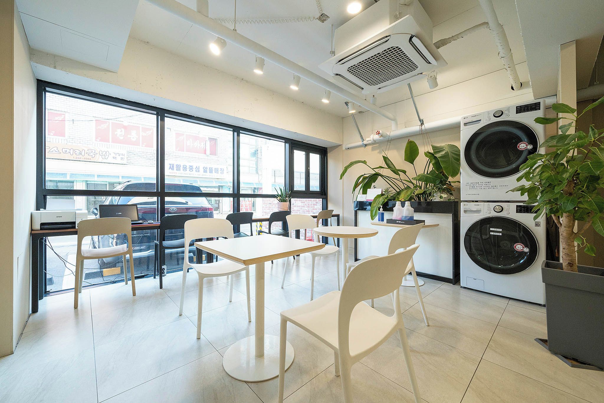 Um interior moderno com área de refeições, janelas amplas e máquina de lavar roupa.