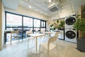 Un interior moderno con zona de comedor, ventanas amplias y lavadora.