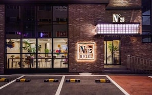 Un hotel con fachada de ladrillo, un cartel que dice 'Nº 25 HOTEL' y una entrada visible.
