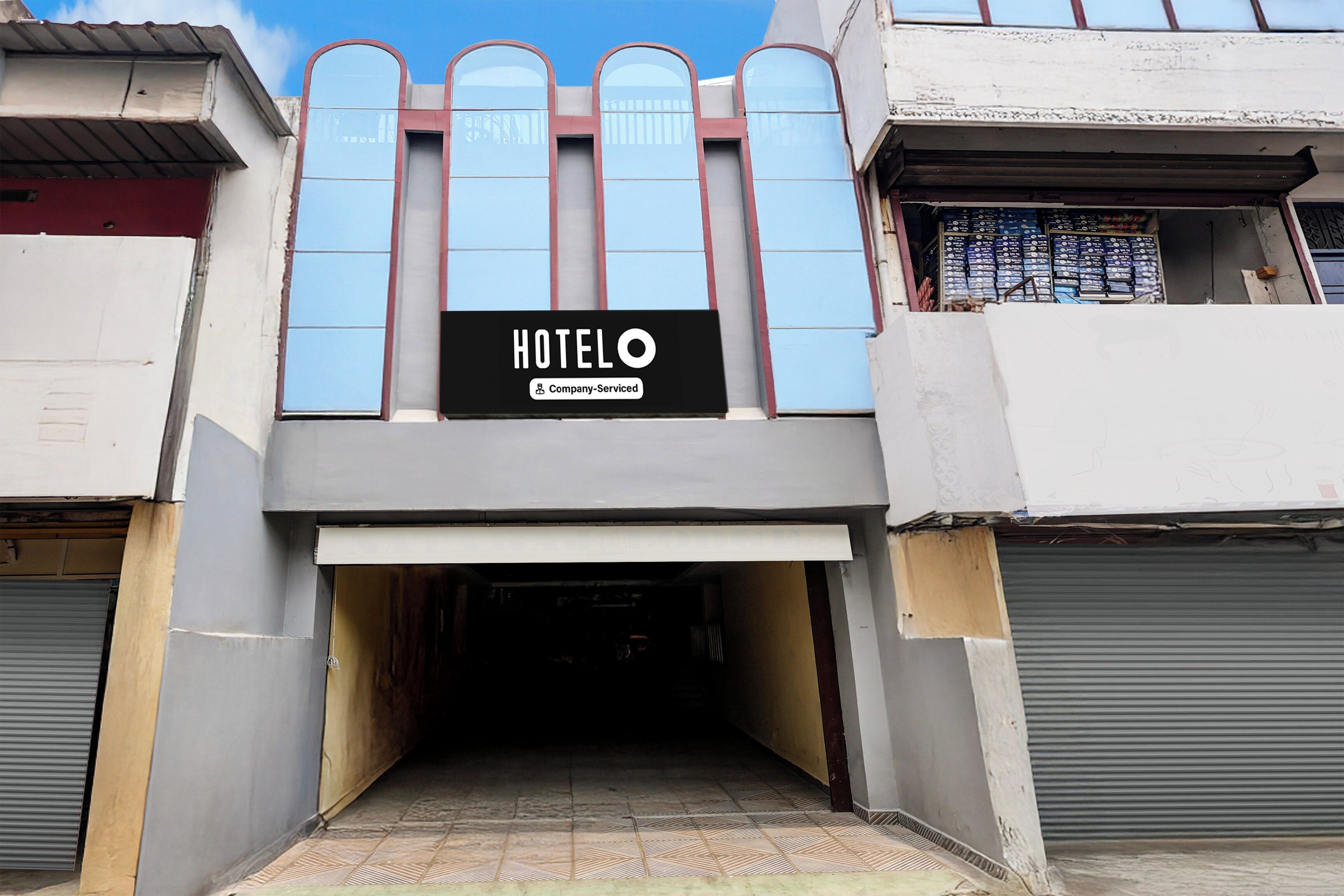A hotel entrance with a sign indicating it's company-serviced.